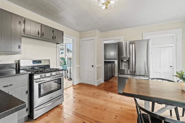 261 Main Ave, South Hampton, NH 03827 - kitchen featuring appliances with stainless steel finishes, dark countertops, ornamental molding, light wood-style floors, and gray cabinets