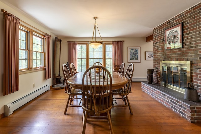 3440 Rte 44, West Windsor, VT 05037 - dining space with baseboard heating, a baseboard heating unit, hardwood / wood-style floors, and a brick fireplace