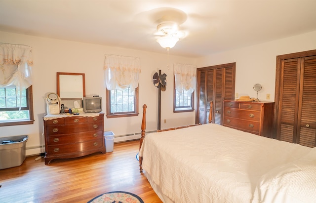 9 Oak Ridge Rd, Kensington, NH 03833 - bedroom with multiple closets, baseboard heating, light wood-type flooring, and a baseboard radiator