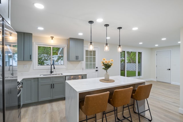 11 Bond St, Hudson, NH 03051 - kitchen featuring gray cabinets, appliances with stainless steel finishes, light wood finished floors, a breakfast bar, and light stone counters