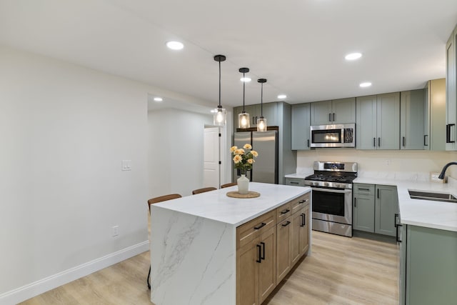 11 Bond St, Hudson, NH 03051 - kitchen featuring stainless steel appliances, light stone countertops, light wood finished floors, a kitchen island, and recessed lighting