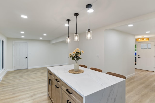 11 Bond St, Hudson, NH 03051 - kitchen with light wood-style flooring, hanging light fixtures, light stone counters, a center island, and recessed lighting