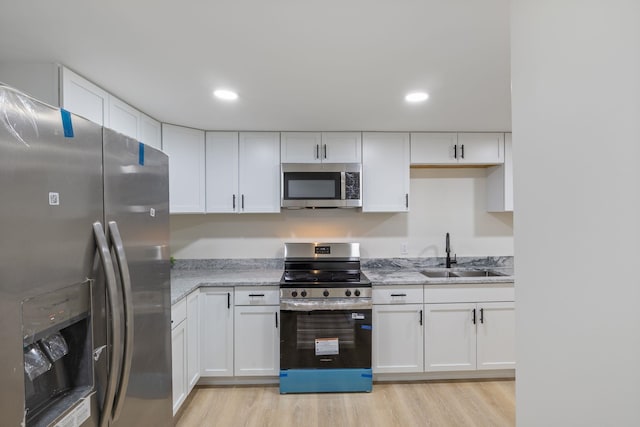 11 Bond St, Hudson, NH 03051 - kitchen with stainless steel appliances, white cabinetry, light wood finished floors, and recessed lighting