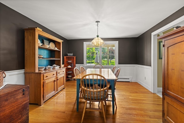 9 Strout Ln, Durham, NH 03824 - dining area featuring a baseboard radiator, a wainscoted wall, light wood-type flooring, and a chandelier