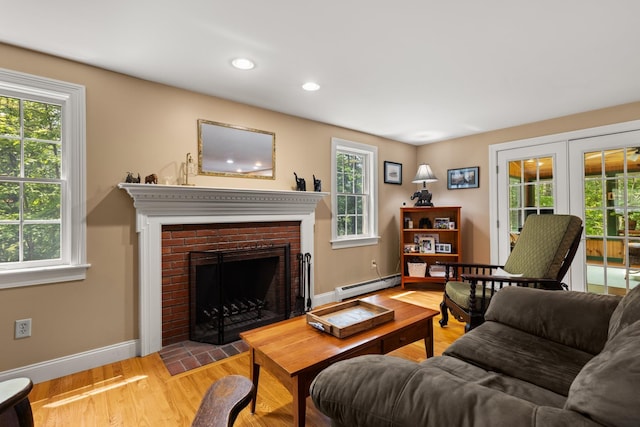 9 Strout Ln, Durham, NH 03824 - living area featuring baseboard heating, plenty of natural light, wood finished floors, a brick fireplace, and recessed lighting