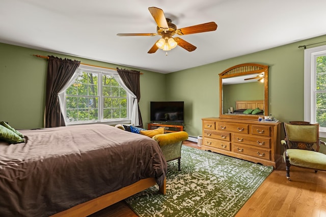 9 Strout Ln, Durham, NH 03824 - bedroom featuring wood finished floors, a baseboard heating unit, and a ceiling fan