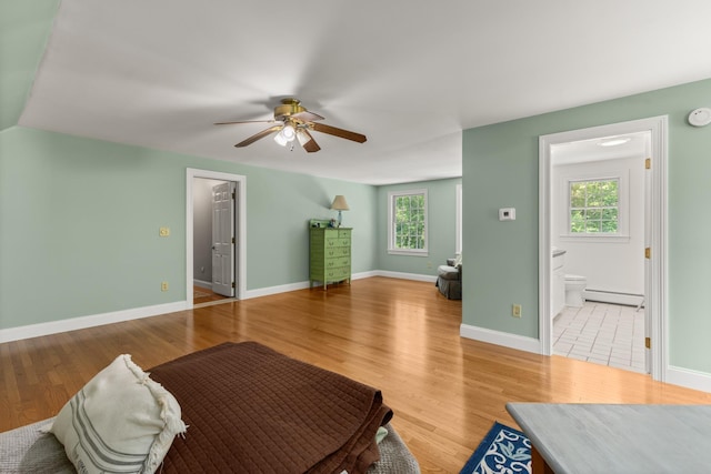 9 Strout Ln, Durham, NH 03824 - living area with a baseboard heating unit, ceiling fan, and wood finished floors