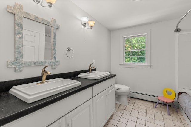9 Strout Ln, Durham, NH 03824 - bathroom with double vanity, baseboard heating, and tile patterned floors