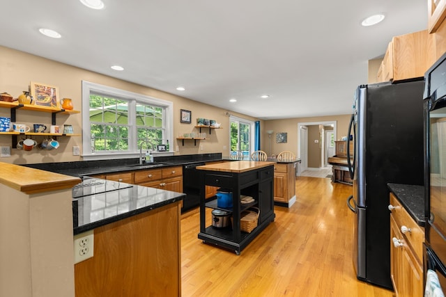 9 Strout Ln, Durham, NH 03824 - kitchen with open shelves, black appliances, light wood-style flooring, recessed lighting, and a center island