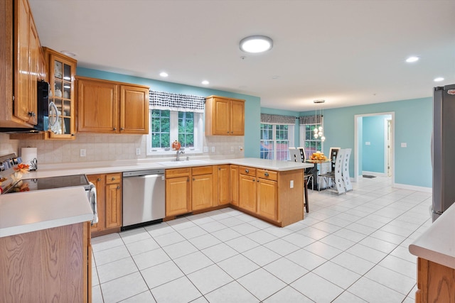 7 Partridge Cir, Salem, NH 03079 - kitchen with appliances with stainless steel finishes, a peninsula, tasteful backsplash, light countertops, and recessed lighting