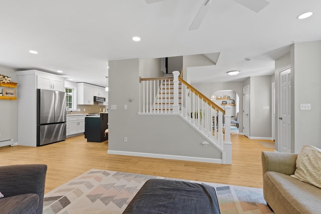 23 Stone Farm Rd, Barrington, NH 03825 - living room featuring stairs, light wood-style floors, ceiling fan, recessed lighting, and arched walkways