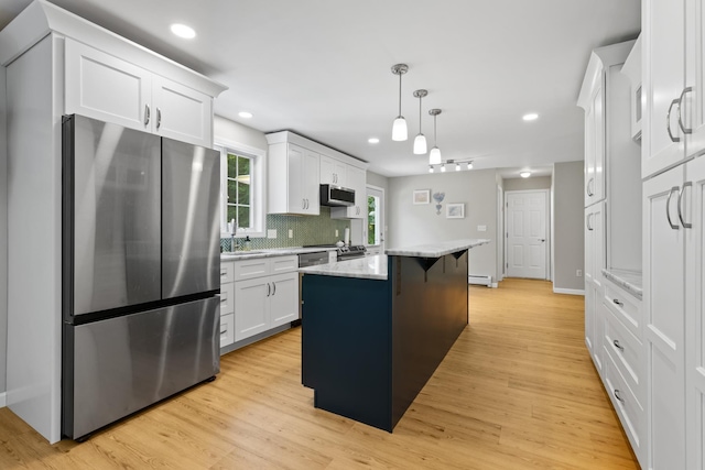 23 Stone Farm Rd, Barrington, NH 03825 - kitchen with stainless steel appliances, a center island, white cabinetry, decorative backsplash, and light wood-type flooring