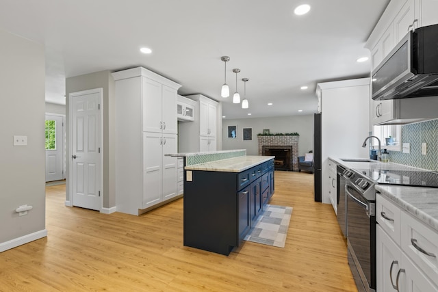 23 Stone Farm Rd, Barrington, NH 03825 - kitchen with electric range oven, white cabinetry, a center island, a brick fireplace, and recessed lighting