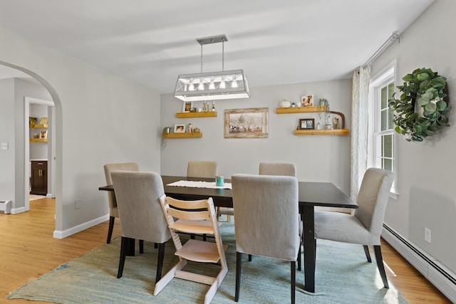 23 Stone Farm Rd, Barrington, NH 03825 - dining space featuring a baseboard radiator, arched walkways, and wood finished floors