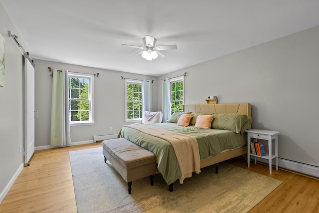 23 Stone Farm Rd, Barrington, NH 03825 - bedroom with a baseboard heating unit, light wood finished floors, a barn door, and ceiling fan