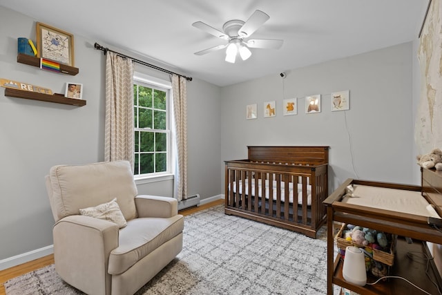 23 Stone Farm Rd, Barrington, NH 03825 - bedroom with wood finished floors, a baseboard heating unit, a crib, and a ceiling fan