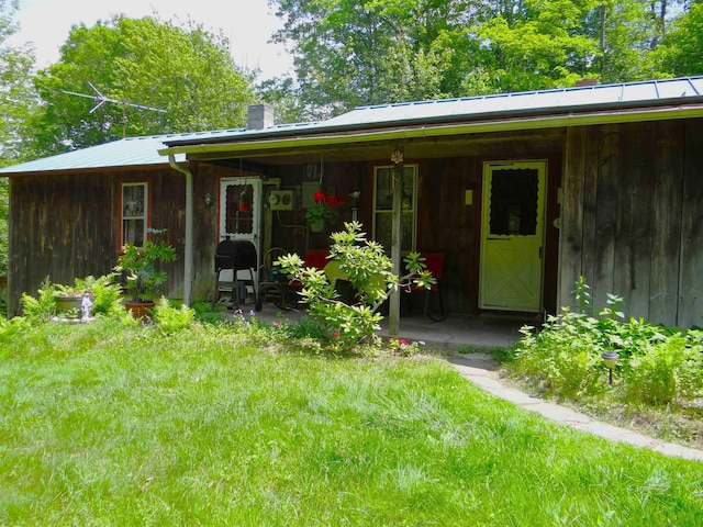 2505 County Rd, Windsor, VT 05089 - rear view of property featuring a chimney, a metal roof, and a yard