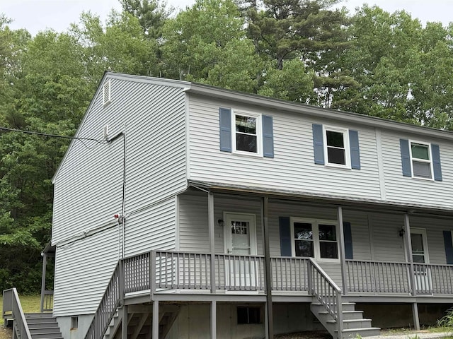 18 Gould Ave Unit 1, Meredith, NH 03253 - view of front of house featuring stairway, view of scattered trees, and a porch