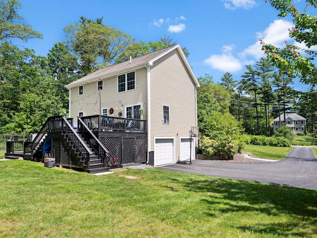 20 Lawrence Rd, Derry, NH 03038 - back of property featuring stairs, an attached garage, driveway, a wooden deck, and a lawn