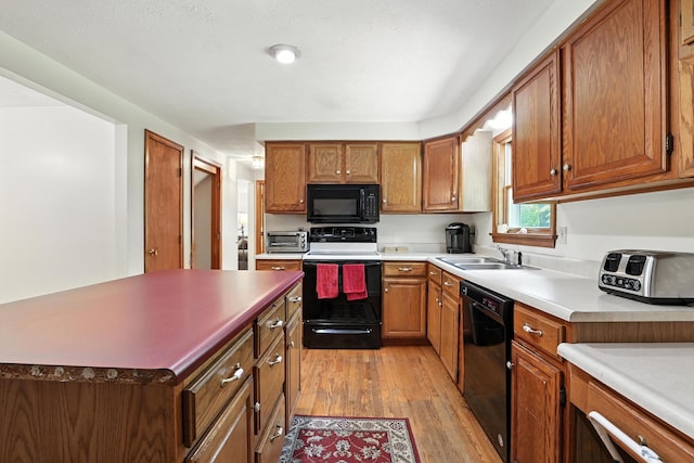 20 Edward Dr, Concord, NH 03301 - kitchen featuring black appliances, light wood-type flooring, brown cabinets, and a kitchen island