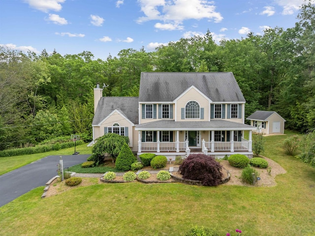 60 Lady Slipper Ln, Chester, NH 03036 - colonial inspired home featuring covered porch, a front lawn, a chimney, and a view of trees
