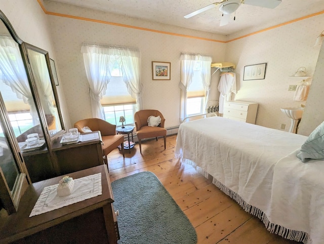 1573 US Route 5 S, Barnet, VT 05821 - bedroom featuring hardwood / wood-style floors, a baseboard heating unit, and a ceiling fan
