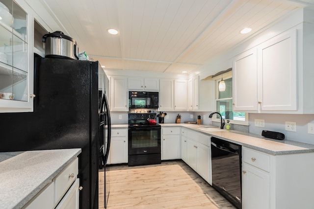 19 Harding Rd, Portsmouth, NH 03801 - kitchen with black appliances, light wood-style flooring, white cabinetry, recessed lighting, and light countertops
