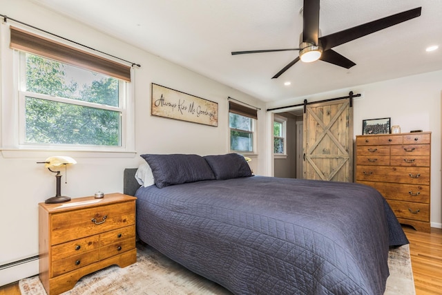 19 Harding Rd, Portsmouth, NH 03801 - bedroom with a baseboard radiator, multiple windows, light wood-style flooring, a barn door, and recessed lighting