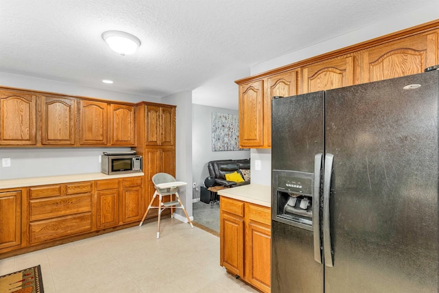 69A Windham Rd Unit A, Hudson, NH 03051 - kitchen with black fridge, stainless steel microwave, brown cabinets, light countertops, and a textured ceiling