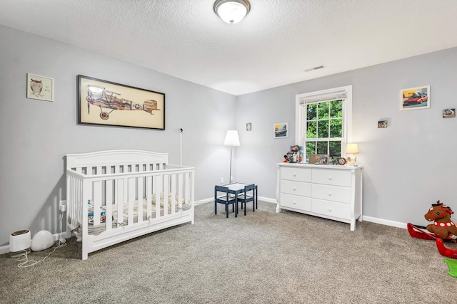 69A Windham Rd Unit A, Hudson, NH 03051 - bedroom with carpet floors, a textured ceiling, and a nursery area