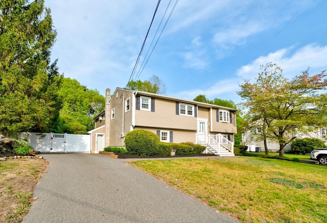 27 Meisner Rd, Salem, NH 03079 - split foyer home featuring a gate, driveway, a chimney, and a garage