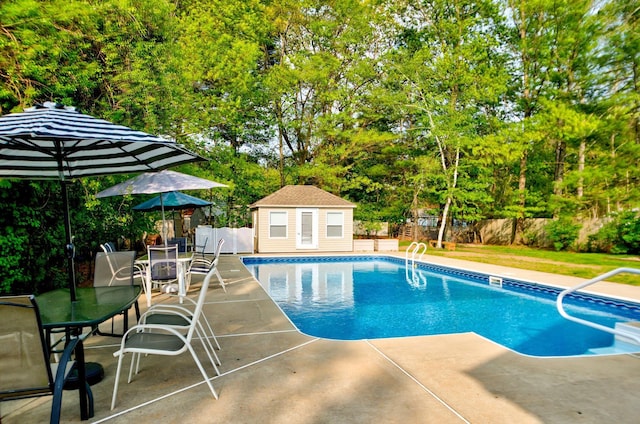 27 Meisner Rd, Salem, NH 03079 - view of pool featuring a patio area, an outbuilding, outdoor dining area, and view of wooded area