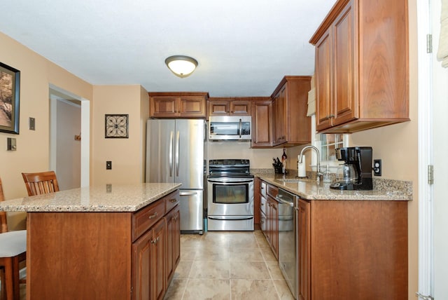 27 Meisner Rd, Salem, NH 03079 - kitchen with stainless steel appliances, a kitchen bar, light stone counters, and brown cabinets