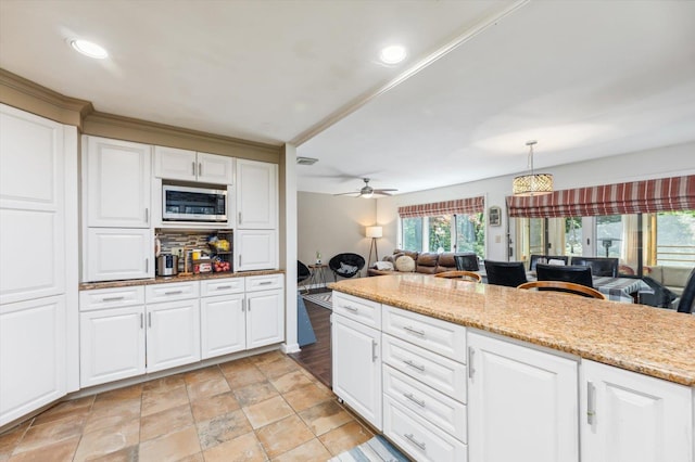 10 Cranberry Rd, Keene, NH 03431 - kitchen with stainless steel microwave, white cabinets, open floor plan, a ceiling fan, and light stone countertops