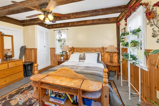 45 Effingham Rd, Ossipee, NH 03864 - bedroom with a wainscoted wall, beamed ceiling, wood walls, a closet, and ceiling fan
