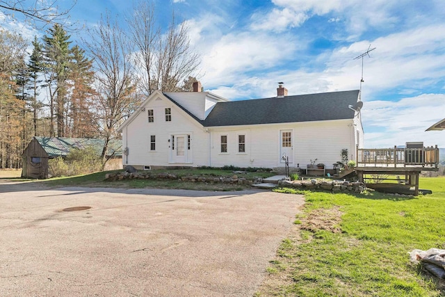 45 Effingham Rd, Ossipee, NH 03864 - view of home's exterior featuring a deck, a chimney, and a lawn
