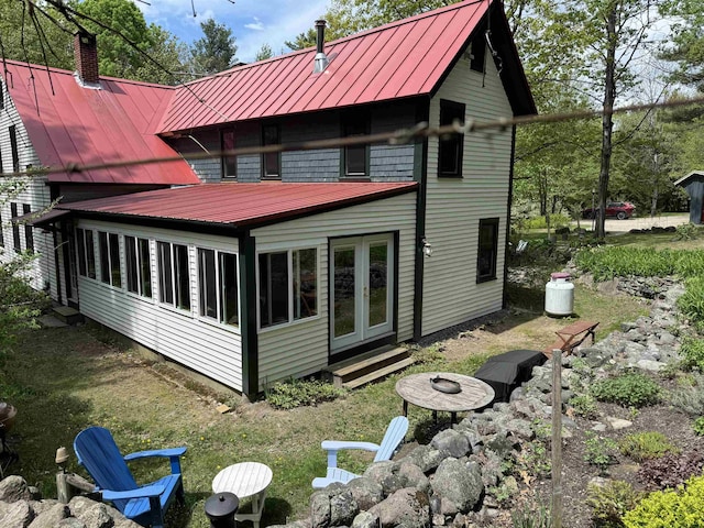197 Circuit Rd, Ossipee, NH 03864 - back of house with a standing seam roof, a chimney, a metal roof, and an outdoor fire pit