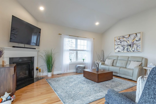 21 Catesby Ln, Londonderry, NH 03053 - living area with wood finished floors, lofted ceiling, a fireplace with flush hearth, and recessed lighting