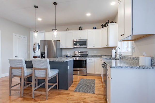 21 Catesby Ln, Londonderry, NH 03053 - kitchen featuring appliances with stainless steel finishes, a center island, light wood-style floors, white cabinetry, and recessed lighting