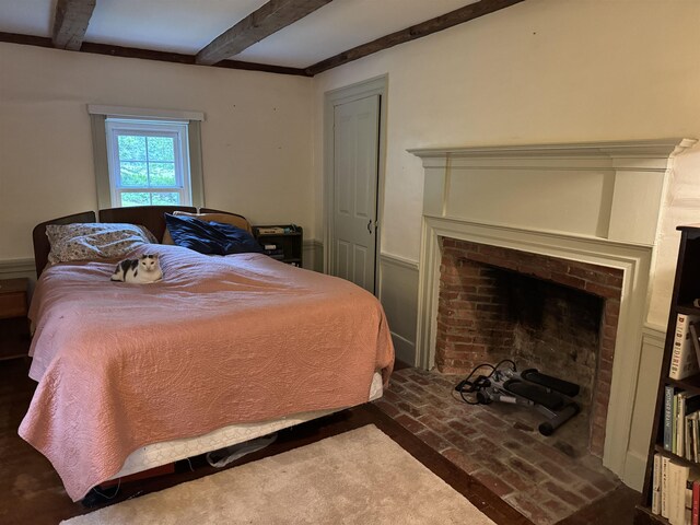275 Granite Rd, Ossipee, NH 03864 - bedroom featuring a fireplace, beam ceiling, and brick floors