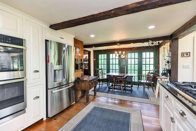 133 Hay Hill Rd, Francestown, NH 03043 - kitchen with appliances with stainless steel finishes, beamed ceiling, dark wood-type flooring, white cabinets, and pendant lighting