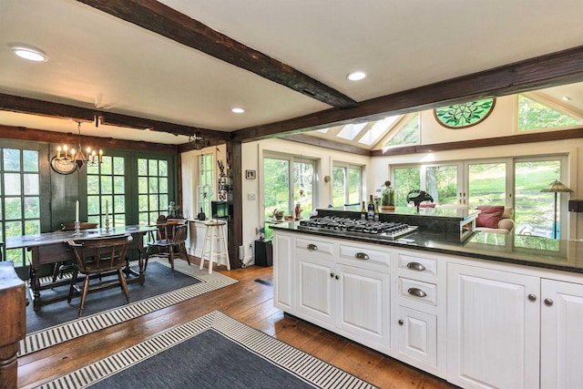 133 Hay Hill Rd, Francestown, NH 03043 - kitchen with dark countertops, beam ceiling, dark wood-style flooring, white cabinets, and stainless steel gas stovetop