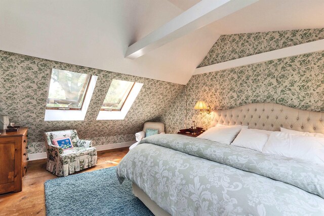 133 Hay Hill Rd, Francestown, NH 03043 - bedroom featuring wallpapered walls, wood finished floors, vaulted ceiling, and a skylight