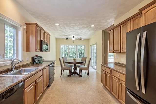 32 Saint Andrews Way, Londonderry, NH 03053 - kitchen with black appliances, dark countertops, recessed lighting, brown cabinets, and light flooring