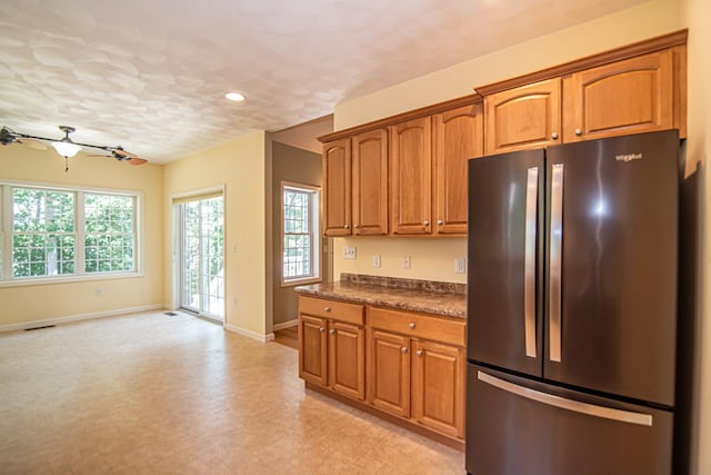 32 Saint Andrews Way, Londonderry, NH 03053 - kitchen with freestanding refrigerator, plenty of natural light, dark countertops, brown cabinets, and recessed lighting