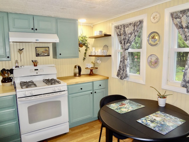 1 Northbrook Rd, Tilton, NH 03276 - kitchen with white range with gas stovetop, under cabinet range hood, ornamental molding, open shelves, and light wood finished floors