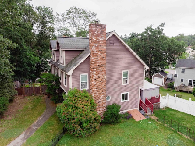 5 Gayle Dr Unit L, Derry, NH 03038 - view of property exterior with a chimney, a fenced backyard, and roof with shingles