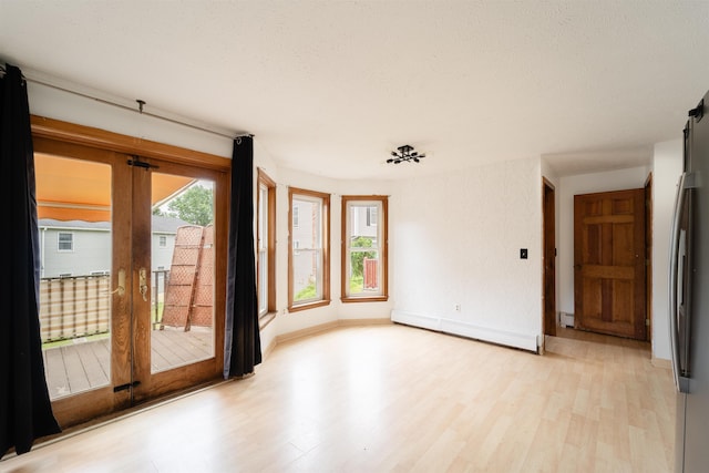 5 Gayle Dr Unit L, Derry, NH 03038 - unfurnished room with a baseboard heating unit, light wood-style floors, and a textured ceiling