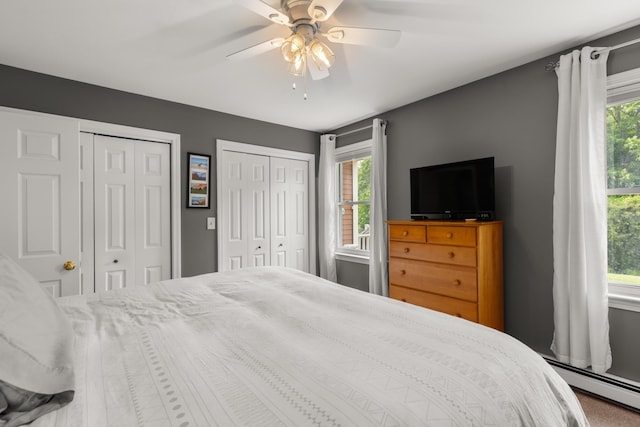 111 Katie Ln, Dover, NH 03820 - bedroom featuring a baseboard heating unit, two closets, multiple windows, and a ceiling fan