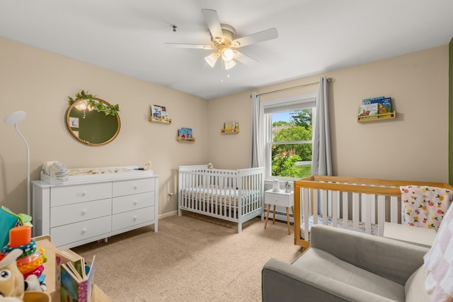 111 Katie Ln, Dover, NH 03820 - carpeted bedroom featuring a crib, a baseboard radiator, and ceiling fan